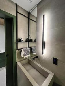 Hub Home - Vista Incrível في كريسيوما: حمام مع حوض ومرآة على الحائط