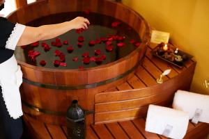 a woman arranging red flowers in a wooden barrel at Hotel Boutique Quinta das Videiras in Florianópolis +79 photos