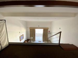 uma sala de estar com uma escada e uma janela em Suite Misión Juriquilla #5 em Juriquilla