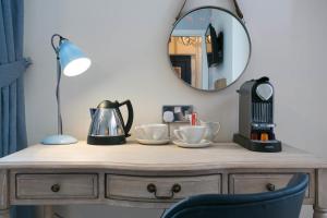 a wooden dresser with a mirror on top of it at The Farmhouse in Derby