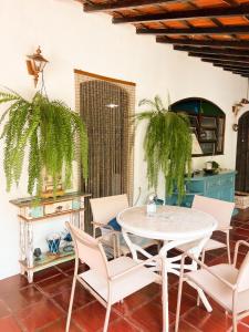 Un comedor con mesa y sillas en Villa Adria, en Ilhabela