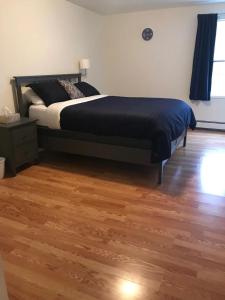 a bedroom with a bed and a wooden floor at Walk 2mins to West Point Academy! Private 2br on Main in HEART of Highland Falls in Highland Falls