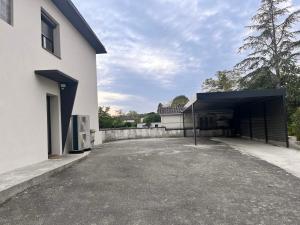 un edificio blanco con un aparcamiento con garaje en Maison du parc, en Vernet