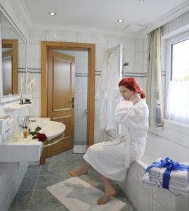 a woman is sitting on a toilet in a bathroom at Alpenbad in Ramsau am Dachstein