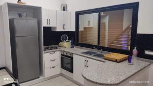 a kitchen with a white refrigerator and a sink at Kelibia beach luxury maison in Kelibia