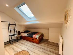 a attic bedroom with a bed and a skylight at Le nid douillet d Annet sur Marne in Annet-sur-Marne