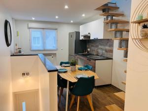 een kleine keuken met een tafel en stoelen in een kamer bij Le nid douillet d Annet sur Marne in Annet-sur-Marne