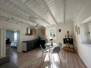 a kitchen and living room with a table and chairs at Agriturismo Maison 1933 in Caprino Veronese