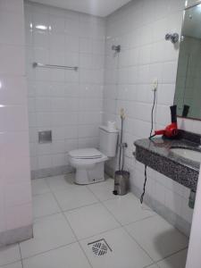 a bathroom with a toilet and a sink and a mirror at Feira Palace Hotel in Feira de Santana