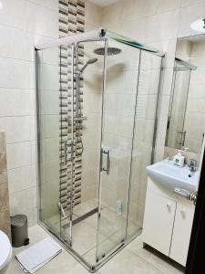 a shower with a glass door in a bathroom at Wyspa Uznam Promenada Konopnickiej in Świnoujście