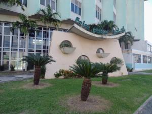 zwei Palmen vor einem Gebäude in der Unterkunft Feira Palace Hotel in Feira de Santana