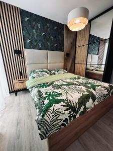 a bedroom with a bed with a green and white comforter at Wyspa Uznam Promenada Konopnickiej in Świnoujście