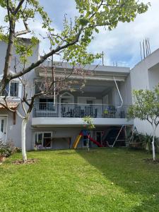 uma casa branca com um quintal à frente em Serenity place em Patra