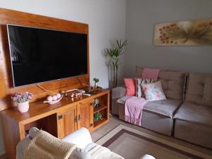 a living room with a couch and a flat screen tv at Casa da Nice in Guaratinguetá