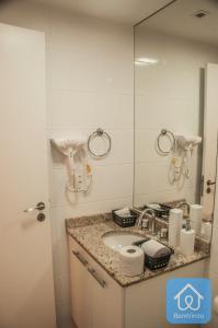 La salle de bains est pourvue d'un lavabo et d'un miroir. dans l'établissement Apartamento completo ao lado do Salvador Shopping, à Salvador