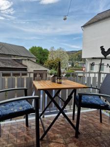 una mesa y 2 sillas en un patio con una botella de vino en Ferienhaus SteigRhein en Filsen