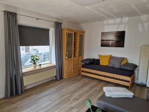 ein Wohnzimmer mit einem Sofa und einem Fenster in der Unterkunft Ferienhaus SteigRhein in Filsen