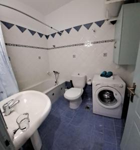 een badkamer met een toilet, een wastafel en een wasmachine bij spiros house in Katochorion