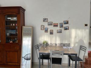 Côt’et Calme في سان مالو: طاولة طعام مع كراسي وصور على الحائط