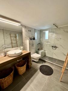 y baño con lavabo, aseo y ducha. en Noema Urban Apartment, en Kavala