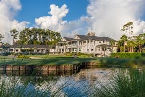 une grande maison sur un parcours de golf avec un étang dans l'établissement Inn and Club at Harbour Town, à Île de Hilton-Head