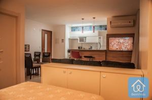 a living room and kitchen with a couch and a table at Apartamento completo ao lado do Salvador Shopping in Salvador