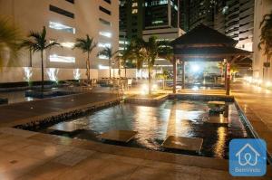 uma piscina com um gazebo numa cidade à noite em Apartamento completo ao lado do Salvador Shopping em Salvador