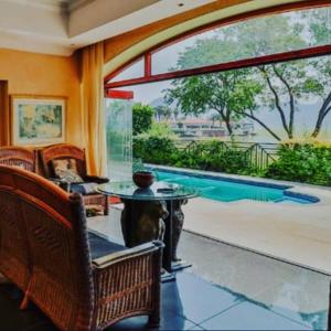 a living room with a large window and a pool at Pecanwood villa on Hartbeespoort Dam in Hartbeespoort