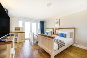 a bedroom with a bed and a desk and a computer at Carbis Bay - Luxury 3 Bed Penthouse Apartment with Sea Views Parking Sauna Balcony in Carbis Bay
