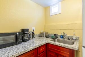 a kitchen counter with a sink and a microwave at @ Marbella Lane - 2BR Cozy LwrLvl in DTWN SJ in San Jose +5 photos