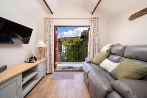 ein Wohnzimmer mit einem Sofa und einem großen Fenster in der Unterkunft Coachman's Quarters in Lynton