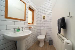 a white bathroom with a sink and a toilet at Coachman's Quarters in Lynton