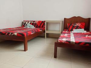 a room with two beds and a table with a bedskirts at Pescador View Extension near the Ocean in Moalboal
