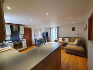 a kitchen and living room with a couch and a table at Swallows Rest in Hexham