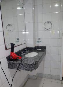 un baño con lavabo con un aparato rojo en Feira Palace Hotel, en Feira de Santana