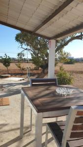 a wooden table with two chairs under a porch at CASA PATY, Estudio rural. Sant Ferran FORMENTERA in San Ferrán de ses Roques