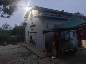 un pequeño edificio blanco con un toldo verde en Altin Patiler Guesthouse, en Çatalca