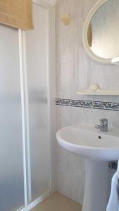 a white bathroom with a sink and a shower at CASA PATY, Estudio rural. Sant Ferran FORMENTERA in San Ferrán de ses Roques