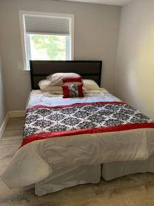 a bed with a black and white quilt and a window at Entire Condo Minutes from Niagara Falls (USA) in Niagara Falls