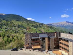 un edificio con una montaña en el fondo en Apartamento de la Marmota Cerler en Cerler