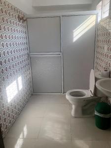 a white bathroom with a toilet and a sink at Casa Hospedaje Villaluz- a 5 minutos de la Playa in Santa Marta