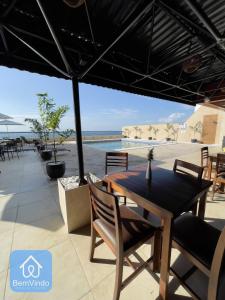 un patio con mesa, sillas y piscina en Apartamento aconchegante com píer e acesso ao Mar, en Salvador