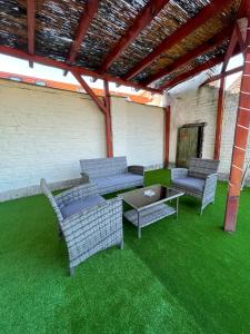 a patio with four chairs and a table on grass at Centrum Hostel in Pécs