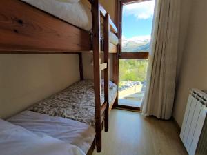 1 Schlafzimmer mit 2 Etagenbetten und einem Fenster in der Unterkunft Apartamento de la Marmota Cerler in Aramón Cerler