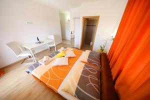 Rooms & Studio apartmani Flower في بيبينيا: غرفة نوم مع سرير وبطانية برتقالية