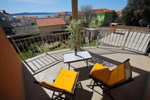 eine Terrasse mit 2 Stühlen und einem Tisch auf dem Balkon in der Unterkunft Rooms & Studio apartmani Flower in Bibinje