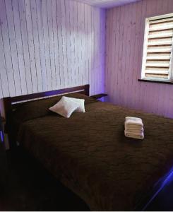 a bedroom with a brown bed with a pillow on it at Садиба Герасімових in Kamianets-Podilskyi