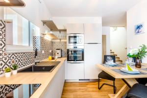 una cucina con mobili bianchi e un tavolo di legno di Dům u Mlejna a Petříkov