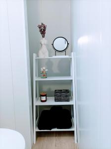 a white shelf in a hallway with a mirror at O balcón do Río in Caldas de Reis +33 photos