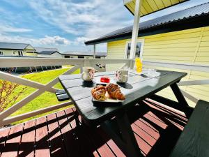 a picnic table with a plate of food on a porch at Holiday Camp Sarbinowo in Sarbinowo